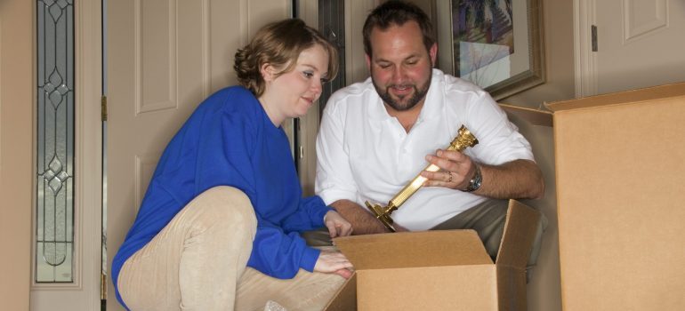 a couple packing a moving box 